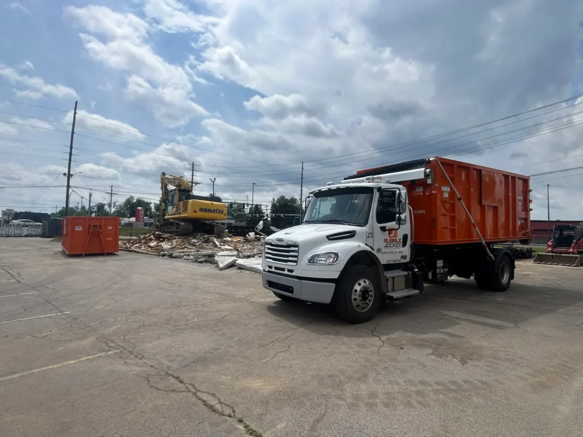 Rubble Jockey hook-lift truck executing a multi-bin 30-yard dumpster exchange for a commercial demolition contractor during an Arby's tear-down on Nicholasville Rd in Lexington, KY.