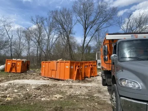 Three Rubble Jockey dumpsters staged on the ground with part of a truck visible at a Spencer Pike project in Mt. Sterling